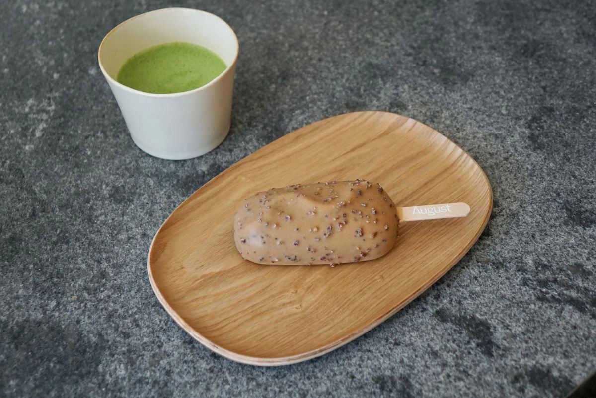 Matcha in cup with ice cream bar on a wood plate