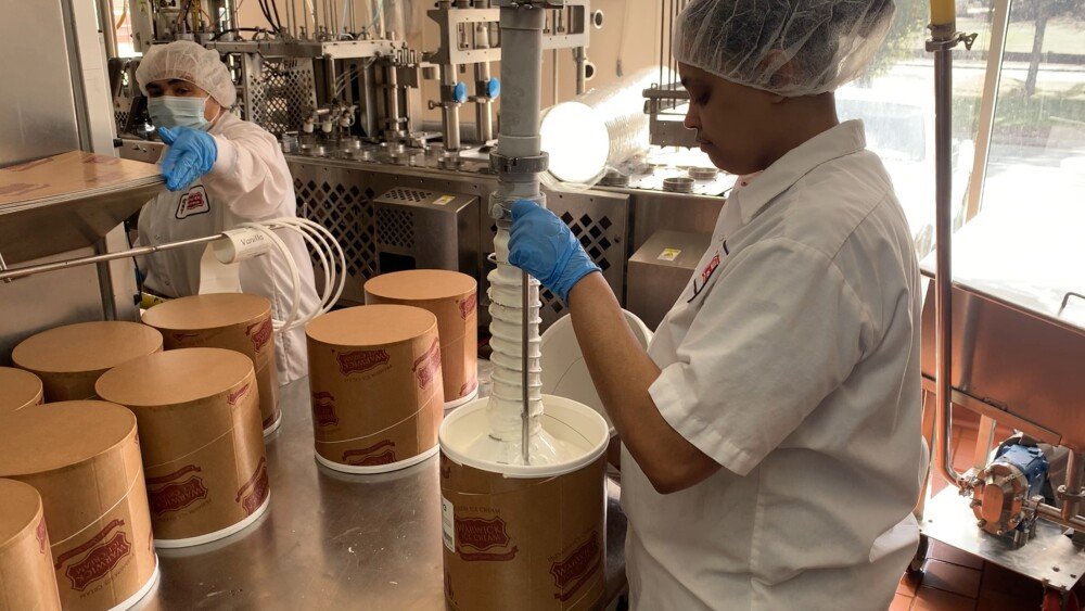 Workers at Warwick Ice Cream churn and package ice cream.