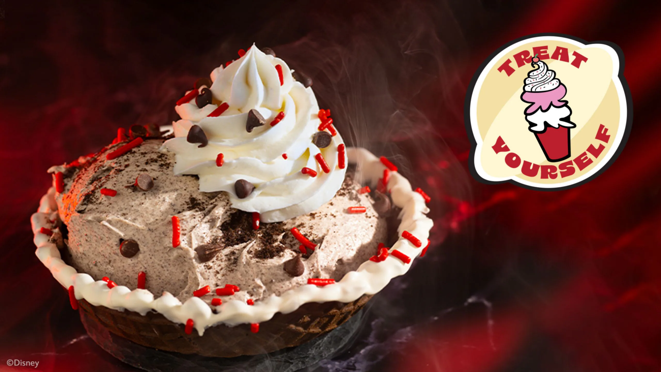 A chocolate ice cream pie with whipped cream, chocolate chips, and red sprinkles sits beside a "Treat Yourself" sign.