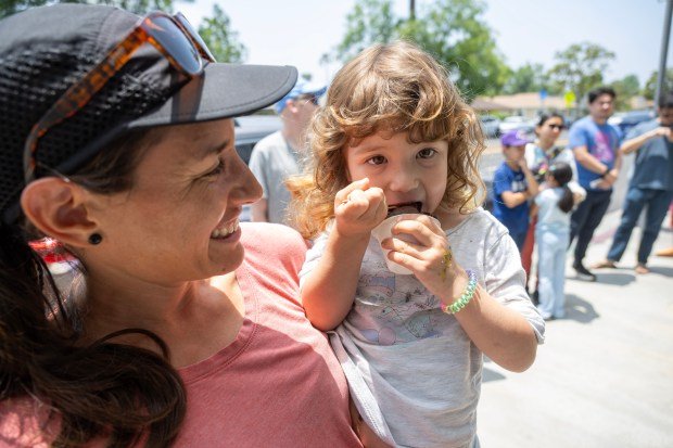 Jennifer Polwerk holds her daughter Abigail, 2-years old, as she...